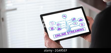 Online streaming concept shown on a tablet held by a man Stock Photo