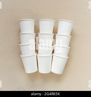Disposable beige cups on beige background.Cups made of biodegradable paper.tableware from paper.plastic free .Bamboo organic cups. Ecology recycling Stock Photo