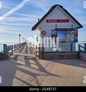 Wooden hut of DLRG, German Lifesaving Society, painted white, in front of a pier on the beach of Lubeck Bay on the Baltic Sea, Travemunde, Germany, Ju Stock Photo