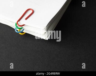 Pile of paper sheets with multicolored paperclips Stock Photo
