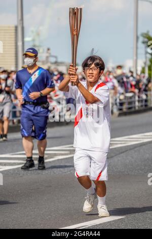 A local torchbearer runs during the Tokyo 2020 Olympic torch relay in Shiogama City, Miyagi Prefecture, Japan on June 20, 2021. Credit: Kosuke Ando/AFLO/Alamy Live News Stock Photo