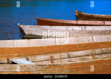traditional fishing wooden flat-bottomed boats on the river bank, rural landscape Stock Photo