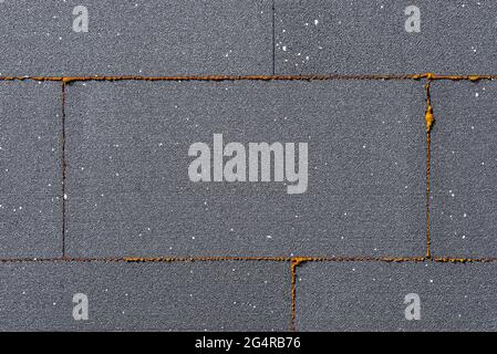 A close-up shot of the buildings insulation is made of graphite polystyrene, there is a yellow mounting foam between the polystyrene. Stock Photo