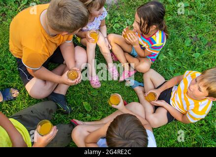 Children are drinking lemonade on the street together. Selective focus. Kids. Stock Photo