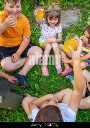 Children are drinking lemonade on the street together. Selective focus. Kids. Stock Photo