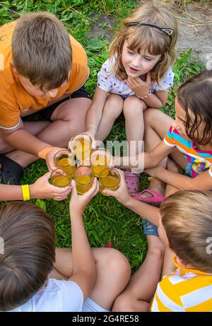 Children are drinking lemonade on the street together. Selective focus. Kids. Stock Photo