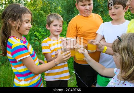 Children are drinking lemonade on the street together. Selective focus. Kids. Stock Photo