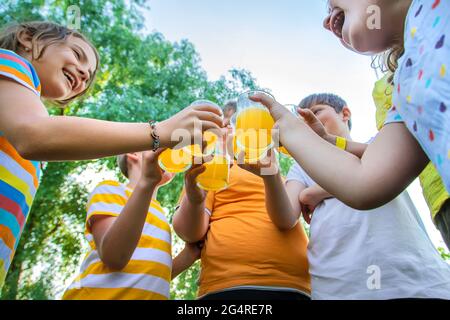 Children are drinking lemonade on the street together. Selective focus. Kids. Stock Photo