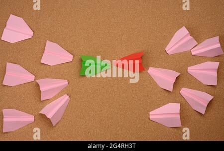 two large groups of paper airplanes on a brown background. Conflict of interest, quarrel and confrontation concept Stock Photo