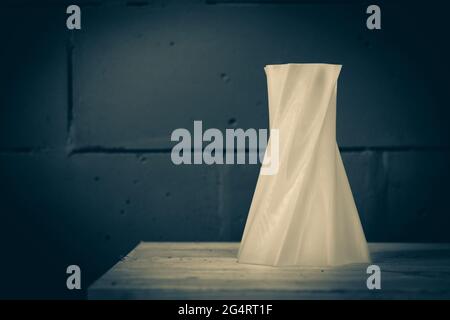 Bright red object vase printed by 3d printer on blue brick wall Stock Photo