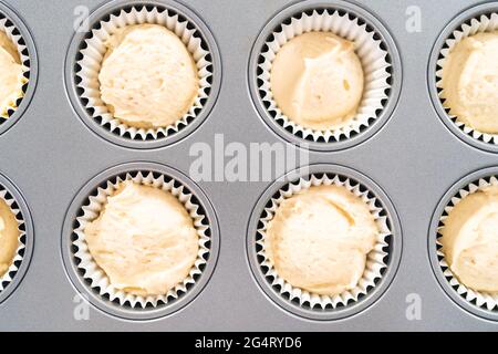 https://l450v.alamy.com/450v/2g4ryd6/scooping-cupcake-batter-into-cupcake-pan-lined-with-cupcake-liners-to-bake-vanilla-cupcakes-2g4ryd6.jpg