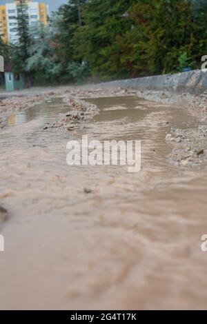 muddy water flowing from the streets after the rain. Stock Photo