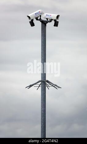 HANNINGFIELD, ESSEX, UNITED KINGDOM - May 26, 2021: Two Aceda security cameras mounted on a high metal pole in an outdoor setting against a cloudy bac Stock Photo