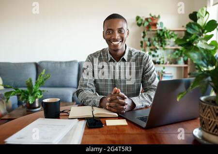Smiling young African businessman working remotely from home Stock Photo