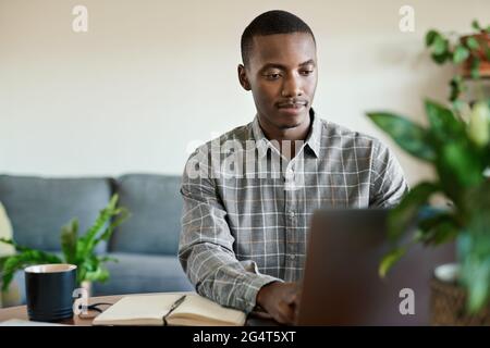Young African businessman working remotely from home Stock Photo