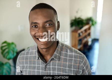 Smiling young African businessman standing at home during a break Stock Photo