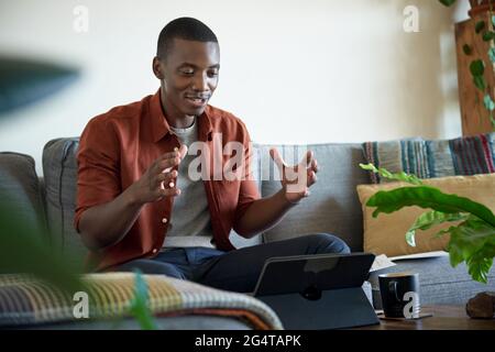 Smiling African man on a video call while working at home Stock Photo
