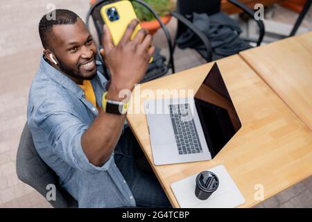 Happy joyful African American male freelancer student using modern laptop holding video meeting or calling social distance friend virtually, smiling Stock Photo
