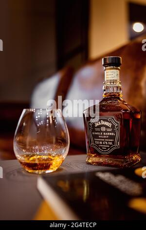 Russia - June 12. 2021, Glass bottle of Jack Daniels Tennessee whiskey on sunset wood toning background. Stock Photo