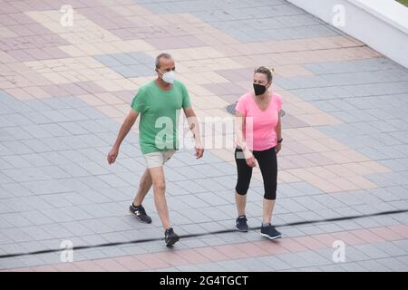 Torrox, Málaga, Spain; June 19 2021: A couple strolls along the promenade next to the beach Stock Photo