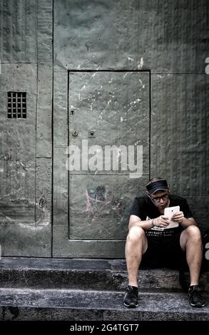 Man sitting on step reading Stock Photo