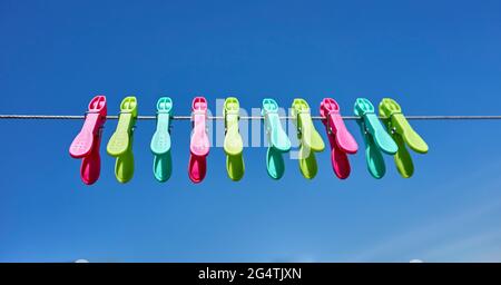 colored clothes pegs against the blue sky Stock Photo