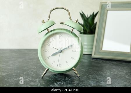 Alarm clock, photo frame and succulent on black smokey table Stock Photo