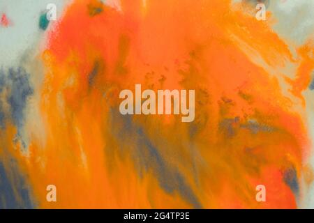 overflowing bright orange and dark blue paint on paper Stock Photo