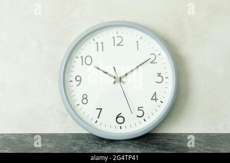 Standard gray clock against white textured background Stock Photo