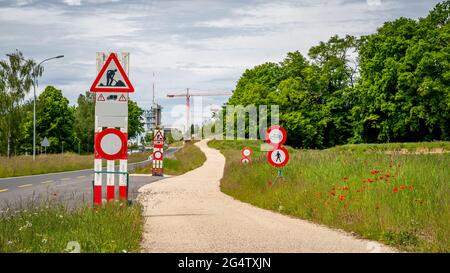 Road work sign under construction.Caution and safety symbol. Red and white triangle safety sign beside the path. Lausanne, Switzerland. Stock Photo