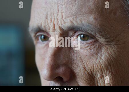 Eyes of an elderly man close-up. Three quarter portrait. A grown man looks away Stock Photo
