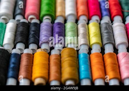 bunch of colorful sew threads lay on dark background isolated Stock Photo