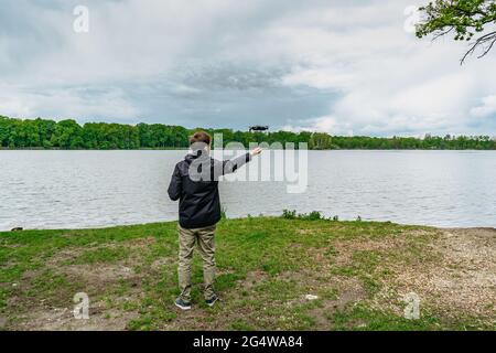 Man playing with drone for exam. Silhouette against fresh spring landscape.Male operating the drone by remote control and having fun. Pilot flying Stock Photo