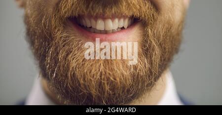 Young bearded hipster man giving smile showing teeth to camera closeup shot Stock Photo