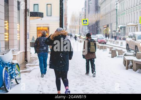 person walk in city streets in winter season under snowfall Stock Photo