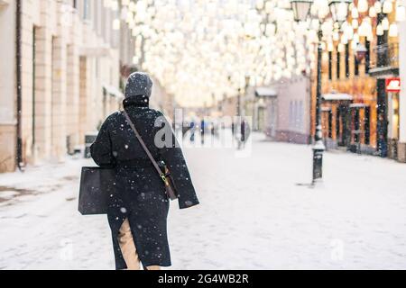 person walk in city streets in winter season under snowfall Stock Photo