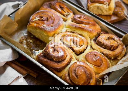 Freshly baked cinnamon buns with spices, walnut and cocoa filling on parchment paper. Top view. Sweet Homemade Pastry christmas baking. Close-up. Kane Stock Photo