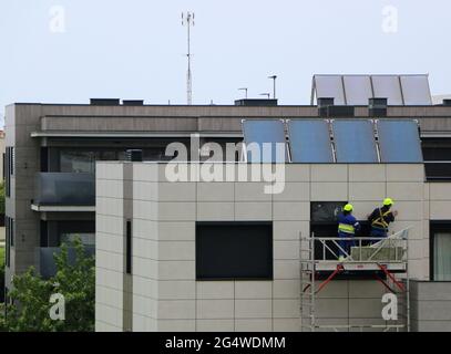 Two workmen repairing water ingression behind cladding on a 1 year old block of flats Santander Cantabria Spain Stock Photo