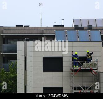 Two workmen repairing water ingression behind cladding on a 1 year old block of flats Santander Cantabria Spain Stock Photo