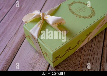 Nice, France - 18.06.2021: Famous French Macaroons from Laduree store. A green special gift box on a wooden background. Assorted Laduree Macaroons in Stock Photo