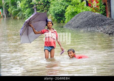 Some moments of naughtiness of two boys on the streets of Kolkata submerged in the rain. Looking at this picture reminds us of our childhood memories. Stock Photo