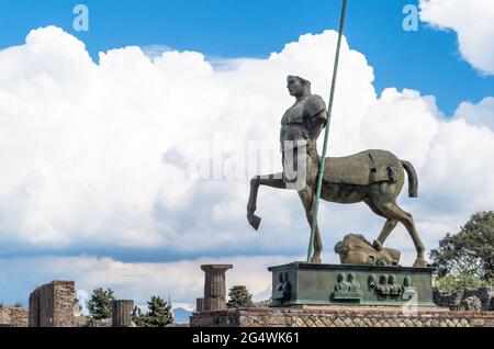 The bronze sculpture of Centaur sculptor Igor Mitoraj donated to Pompeii. Pompeii ruins in Italy, a background of collumns, trees and literally mind b Stock Photo