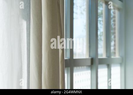 View through light green window frame and half open curtain to the outside. Springtime concept. Image with selective focus. Stock Photo