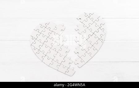 Bold heart shaped puzzle on white table Stock Photo