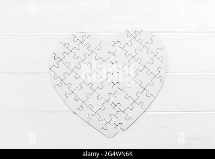 Bold heart shaped puzzle on white table Stock Photo