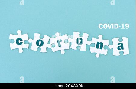 Jigsaw puzzle pieces with corona, blue background Stock Photo