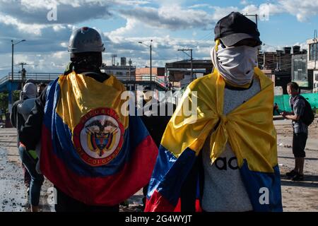 Bogota, Colombia. 21st June, 2021. Demonstrators cover their faces while using Colombia's national flag as capes as clashes between demonstratros and Colombia's riot police erupt anti-government protest raise in Bogota Colombia against the government of president Ivan Duque, inequalities and abuse of authority by police. Credit: Long Visual Press/Alamy Live News Stock Photo