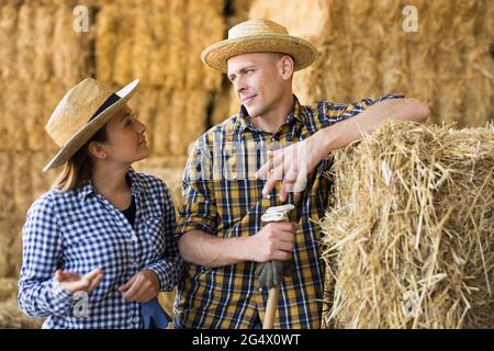 Two hired workers talking during break between work on farm Stock Photo