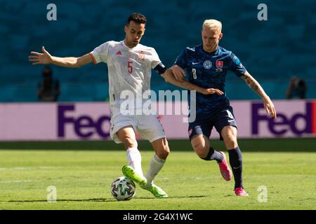 Seville, Spain. 23rd June, 2021. Spain's Sergio Busquets (L) vies with Slovakia's Ondrej Duda during the Group E match between Slovakia and Spain at the UEFA Euro 2020 in Seville, Spain, June 23, 2021. Credit: Meng Dingbo/Xinhua/Alamy Live News Stock Photo