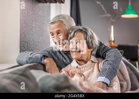 Thoughtful senior couple looking away at home Stock Photo